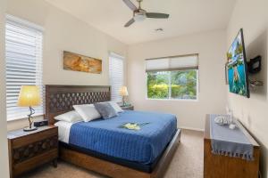 Un dormitorio con una cama azul y una ventana. en Ocean View Villa Sunset Pool King's Luxury experience, en Kailua-Kona