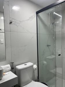 a bathroom with a toilet and a glass shower at Flat no Move em Tambaú in João Pessoa