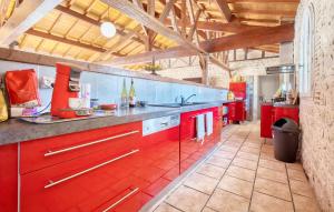 a large kitchen with red cabinets in a room at Charmante Maison Avec Piscine in Saint-Pierre-dʼEyraud