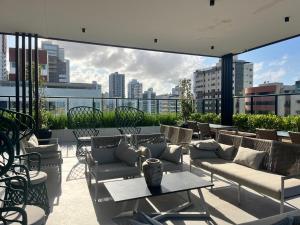 a patio with couches and tables on top of a building at Flat no Move em Tambaú in João Pessoa