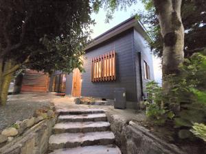 a small blue house with a pathway leading to it at Relaxing箱根彫刻の森ーサウナ付き一棟貸しの宿 in Hakone