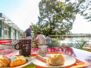 a table with two plates of food and a cup of coffee at ibis Styles Bourbon Lancy in Bourbon-Lancy