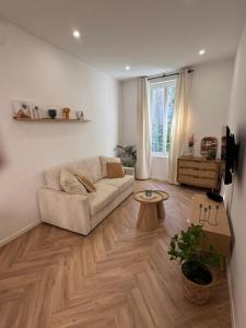 a living room with a couch and a table at Le Cloître du Palais - Studio in Avignon