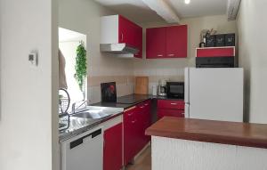 a kitchen with red cabinets and a white refrigerator at Pet Friendly Home In Royères With Wifi in Chénour