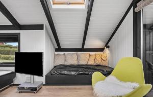 Un dormitorio con una cama, un televisor y una silla. en 2 Bedroom Nice Home In Hejls, en Hejlsminde