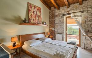 une chambre avec un lit et un mur de briques dans l'établissement Lovely Home In Kastelir, à Kaštelir