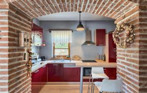 une cuisine avec des armoires rouges et un mur de briques dans l'établissement Lovely Home In Kastelir, à Kaštelir