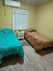 フェデラシオンにあるValentinaのベッド2台とテーブルと窓のある寝室