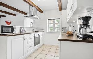a kitchen with white cabinets and a counter top at Awesome Apartment In Tommerup With House A Panoramic View in Render