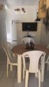 a kitchen with a table and two white chairs at Casa a beira Mar - Ponta de Mangue - Maragogi in Maragogi