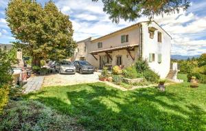 a house with two cars parked in a yard at Grande Maison in Noyers-sur-Jabron