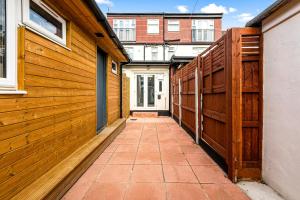 a walkway between two buildings with wooden fences at Imperial Inn Studios in London