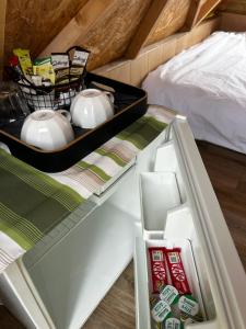 an open refrigerator with tea pots and other items at The Orchard Hideaway in Whitchurch +10 photos