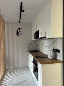 a kitchen with white cabinets and a counter top at Start Life in Vyshhorod +5 photos