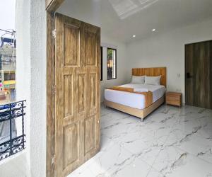 a bedroom with a bed and a large wooden door at Casa Eterna Campo Valdés in Medellín