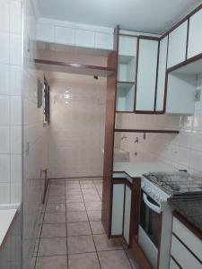 a small kitchen with a sink and a stove at Residencial requinte in Bragança Paulista