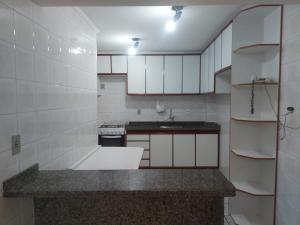 a kitchen with white cabinets and a counter top at Residencial requinte in Bragança Paulista