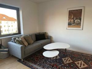 a living room with a couch and a table at Bright & cozy city apartment in Hvidovre