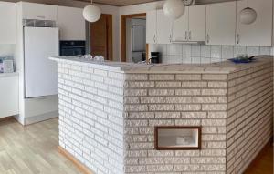 a kitchen with a brick wall in the middle at 2 Bedroom Amazing Home In Samsø in Ballen