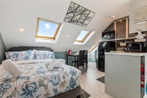 a small bedroom with a bed and a kitchen at Imperial Inn Studios in London