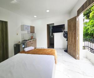 a bedroom with a large bed and a kitchen at Casa Eterna Campo Valdés in Medellín