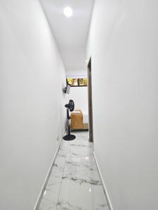a hallway with white walls and a white floor with a camera on a tripod at Casa Eterna Campo Valdés in Medellín
