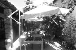 レシフェにあるPousada Hostel capitão da praiaのパティオ(パラソルの下にテーブルと椅子付)