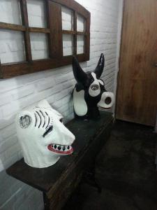 レシフェにあるPousada Hostel capitão da praiaのテーブルの上に牛とマスクの彫刻が2つある