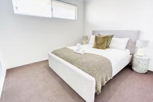 Un dormitorio blanco con una gran cama blanca y una ventana. en Casa de Reis - Beach House, en Dunsborough