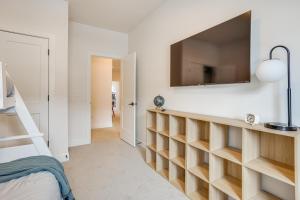 1 dormitorio con TV en la pared y 1 cama en Hike and Ski Townhome 8 Mi to Dtwn Ogden!, en Hooper