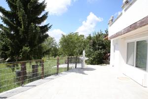 a white house with a fence and a statue at Gästehaus Café Daheim - Self Check-in in Buoch