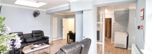 a living room with black leather chairs and a table at Regina's Place in London