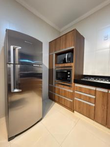 a kitchen with a stainless steel refrigerator and a microwave at Sua casa em Orlândia in Orlândia