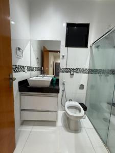 a bathroom with a toilet and a sink and a shower at Sua casa em Orlândia in Orlândia