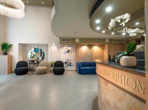 a lobby of a hotel with a reception desk and chairs at CHLOE Hotel Budapest in Budapest
