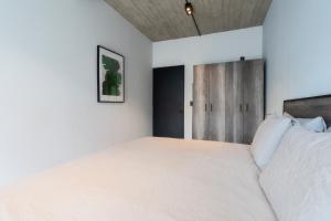 a bedroom with a large bed with white sheets at Zielo 2bdrm 2 bath Private balcony, Rooftop Walk to Zocalo in Mexico City