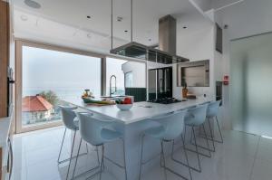 梅彻林基Przystań Mechelinki- Marina Del Mar的厨房里有一个带吧台凳的大岛台