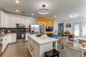 a kitchen with an island in the middle of a room at The Q - Austin Family Home - Hot Tub & Golf Sim in Austin