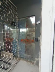 a glass door in a room with a brick wall at Vila do Chaves Bruxa do 71 in Itajaí