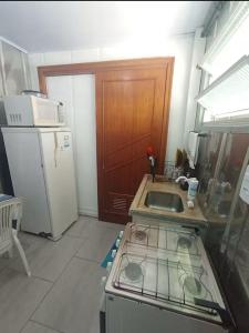 a small kitchen with a sink and a refrigerator at Vila do Chaves Bruxa do 71 in Itajaí