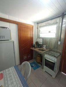a small kitchen with a stove and a sink at Vila do Chaves Bruxa do 71 in Itajaí +2 photos