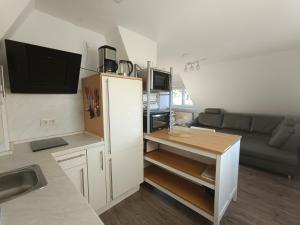 a kitchen with a refrigerator and a living room with a couch at Ferienwohnung Michelle mit Balkon für 1 - 6 Personen in Warmensteinach