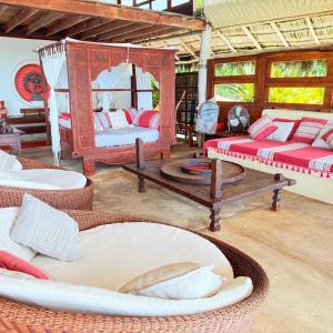 a room with two beds and wicker chairs at Palapa Ganesh in Sayulita +22 photos