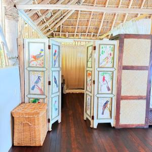 a room with four doors with paintings of birds at Palapa Ganesh in Sayulita