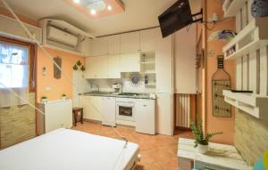 マルティンシクーロにあるBeautiful Apartment In Martinsicuro With Wifiの白いキャビネットとテレビ付きのキッチン
