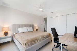 una camera da letto con un letto, una scrivania e una sedia di Golf Course Ocean View Penthouse Reserva Conchal a Brasilito