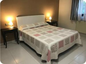 a bedroom with a large bed with two night stands at Duplex con Garaje in Villamayor