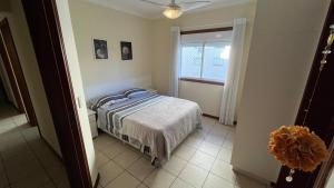 a bedroom with a bed and a window at Apto CAPAO DA CANOA Ed GABRIELA 6 Pers in Capão da Canoa