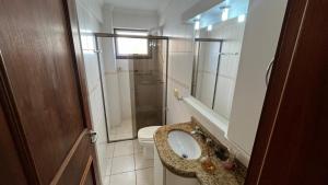a bathroom with a sink and a toilet and a mirror at Apto CAPAO DA CANOA Ed GABRIELA 6 Pers in Capão da Canoa