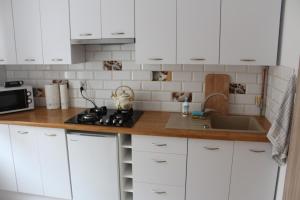 a kitchen with white cabinets and a sink at Stara Kamienica Centrum in Mrągowo